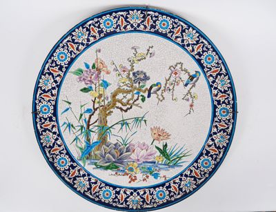 une assiette bleue et blanche ornée d'un motif représentant des oiseaux et des fleurs