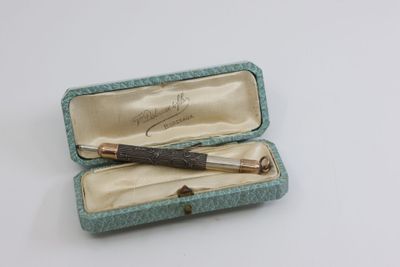 une petite boîte contenant un stylo, posée sur une table