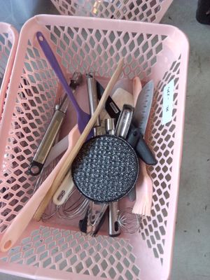 un panier rose rempli de divers ustensiles de cuisine