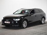 Un SUV Audi noir est garé dans une pièce blanche