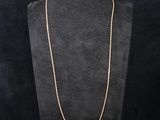 a gold chain necklace on a mannequin display