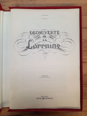 un livre ouvert posé sur une table en bois, à côté d'une tasse de café