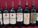 Plusieurs bouteilles de vin sont alignées sur une surface rouge