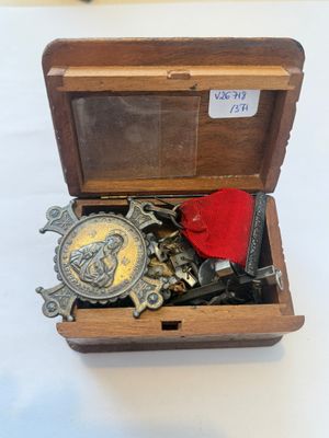 a small wooden box with a medal and other items in it