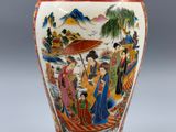 un vase avec un tableau posé sur une table