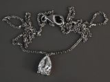 un collier en argent orné d'un diamant en forme de larme