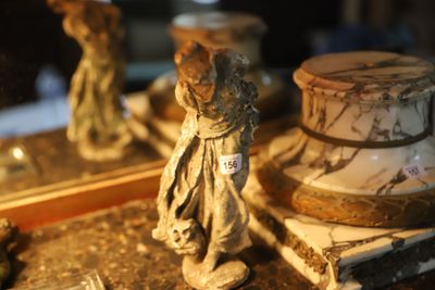 a small statue of a woman standing next to a mirror