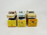 three toy cars are sitting in boxes on a white surface