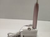 a pink toothbrush sitting on a white table