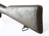 an old gun is sitting on a stand on a white surface