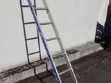 two ladders leaning against a wall next to a truck