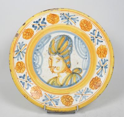 un gros plan sur une assiette jaune et bleue sur laquelle figure l'image d'une femme