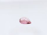 a close up of a pink diamond on a white surface
