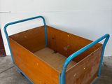 a wooden box with a blue handle on a dolly