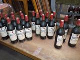 many bottles of wine sitting on a wooden table