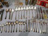 a lot of silver spoons and forks on a table