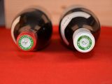 two bottles of wine sitting on a red cloth
