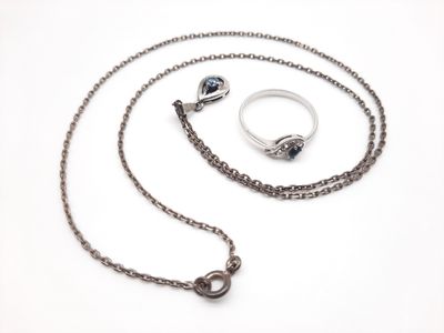 Photo d'un collier et d'une bague avec une chaîne sur fond blanc