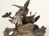 bronze statue of a woman on a rock with a bird in her hand