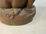 a statue of a woman sitting on top of a rock