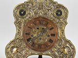une image représentant une horloge dorée dont le cadran est orné de chiffres romains