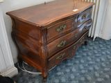 a wooden dresser with a mirror on top of it in a room