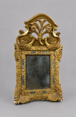 un cadre doré richement décoré, avec un miroir au centre