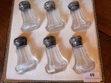 six glass salt and pepper shakers in a box on a table