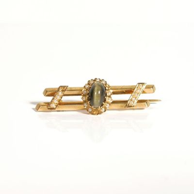 une photo d'une bague en or sertie d'une pierre verte et de diamants