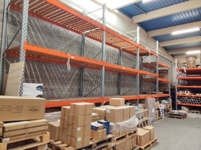 Les cartons sont empilés sur des palettes dans un entrepôt au toit bleu