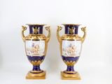 pair of blue and gold vases sitting on top of a white table