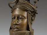 a bronze head of a woman with a crown on her head