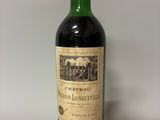 une bouteille de vin rouge avec un bouchon doré sur fond blanc