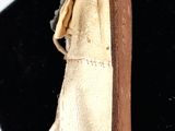 a gold shoe with a bow on it on a black surface