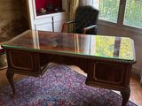 un bureau avec un plateau en verre, dans un coin de la pièce
