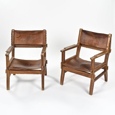 deux chaises en cuir marron assises l'une à côté de l'autre sur une surface blanche