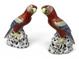 pair of red and green parrot figurines sitting on top of each other