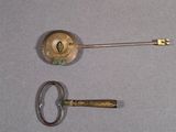 a small key and a small metal object on a table