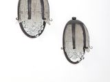 une paire de boucles d'oreilles noires et argentées sur fond blanc