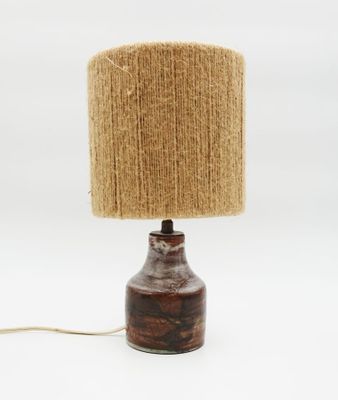 a close up of a lamp on a white surface with a brown shade