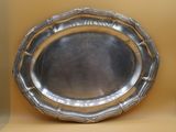 a silver plate that is sitting on a shelf