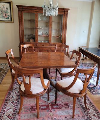 une table de salle à manger avec des chaises et un lustre en arrière-plan
