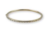a yellow gold bang bracelet with small diamonds