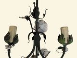 a chandelier with three candles and flowers on it