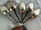 five spoons in the shape of a flower on a table