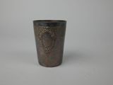 un gros plan d'une tasse en métal posée sur une surface blanche