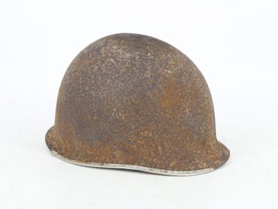 a rusty helmet on a white surface with a white background