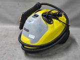 a close up of a yellow and black steam cleaner on a gray surface