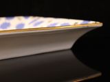 a close up of a blue and white plate on a black surface