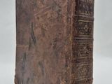 an old book sitting on top of a white surface